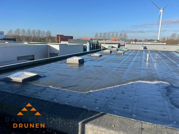 Plat dak bedrijfspand met bitumen dakbedekking en lichtkoepels in Drunen