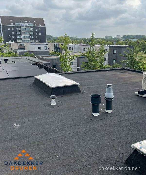 Groot plat dak met lichtkoepel en dakdoorvoeren in Drunen Groot plat dak met lichtkoepel en dakdoorvoeren in Drunen