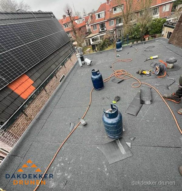 Daklekkage repareren met brandgereedschap op plat dak in Drunen