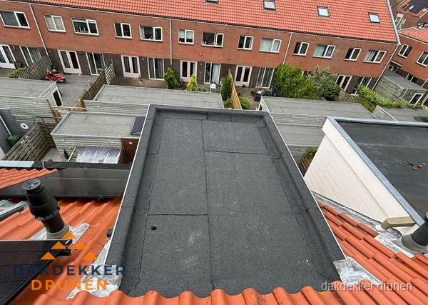 Plat dak met bitumen bedekking naast dakkapel in Drunen