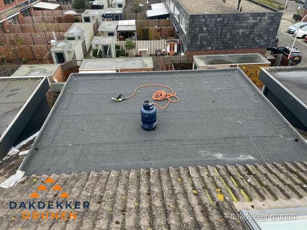 Plat dak met nieuwe bitumen dakbedekking en brandgereedschap in Drunen