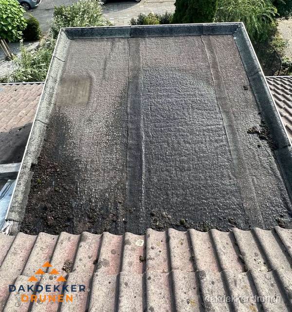Verouderd plat dak met bitumen en slijtage voor lekkage inspectie in Drunen