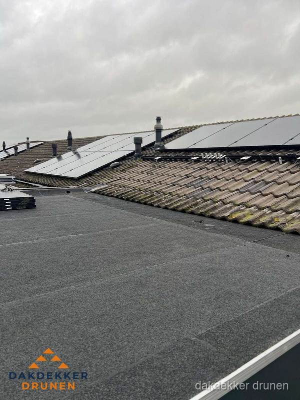 Bitumen dakbedekking op plat dak met aansluitend pannendak en zonnepanelen in Drunen