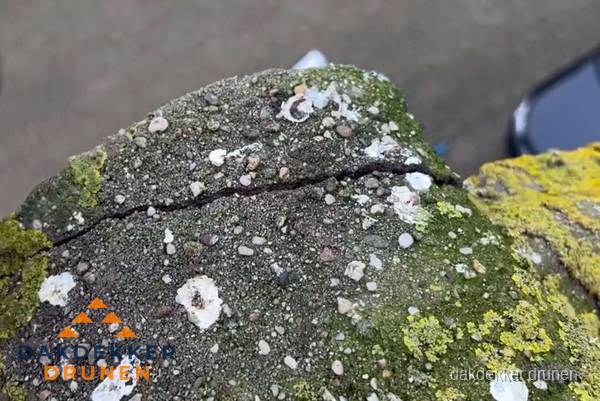Beschadigde en verweerde nokvorst met scheuren en mos in Drunen