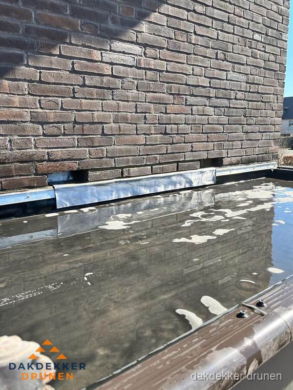 Stilstaand water op plat dak door slechte afwatering in Drunen Stilstaand water op plat dak door slechte afwatering in Drunen