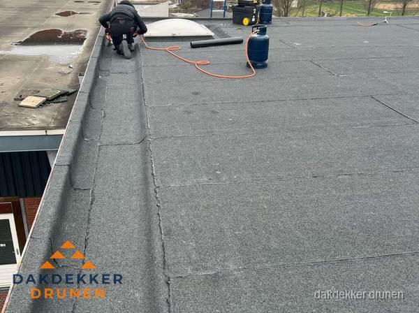 Dakdekker repareert bitumen dakbedekking op groot plat dak in Drunen Dakdekker repareert bitumen dakbedekking op groot plat dak in Drunen