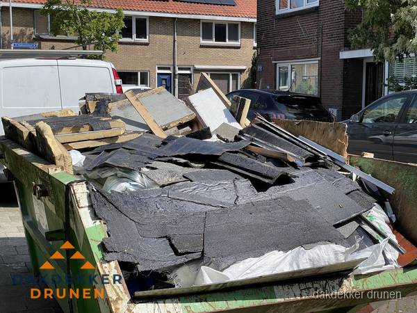 Afvalcontainer met gesloopt dakmateriaal tijdens dakkapel renovatie in Drunen Afvalcontainer met gesloopt dakmateriaal tijdens dakkapel renovatie in Drunen