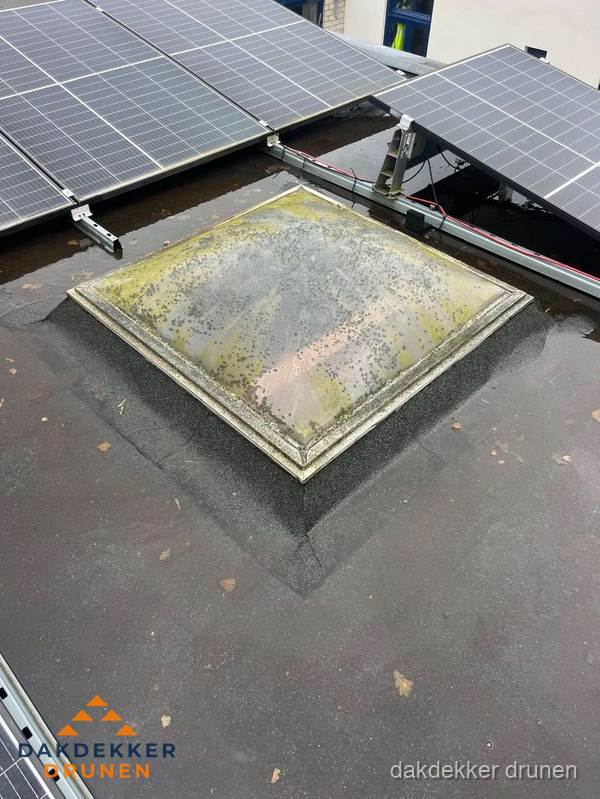 Vervuilde lichtkoepel op plat dak met zonnepanelen in Drunen Vervuilde lichtkoepel op plat dak met zonnepanelen in Drunen