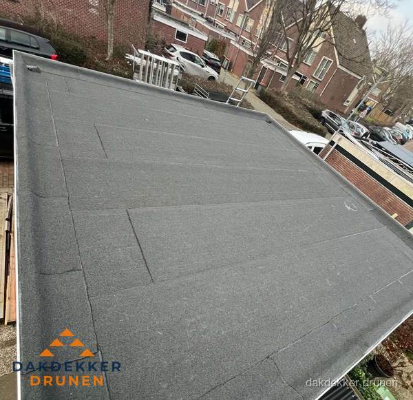 Nieuwe bitumen dakbedekking op plat dak van garage in Drunen